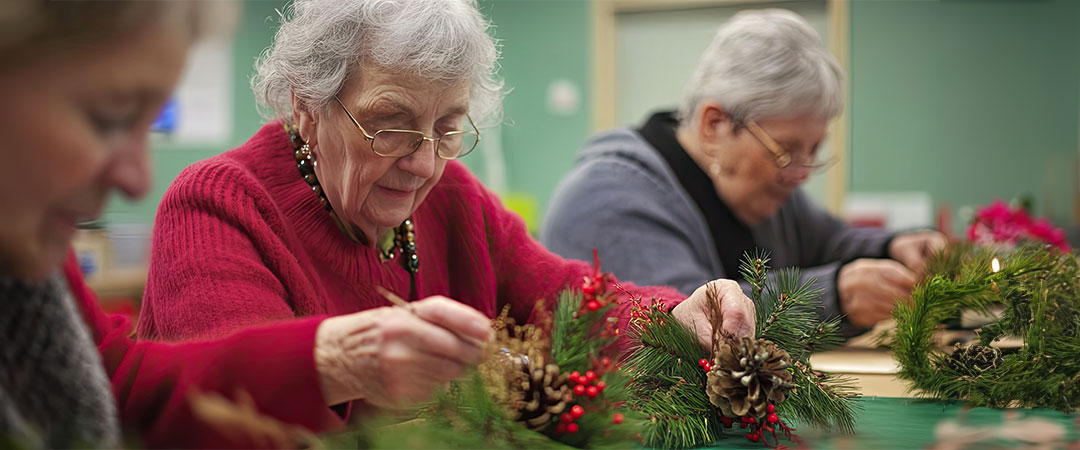 Senior doing holiday crafts together at a table.